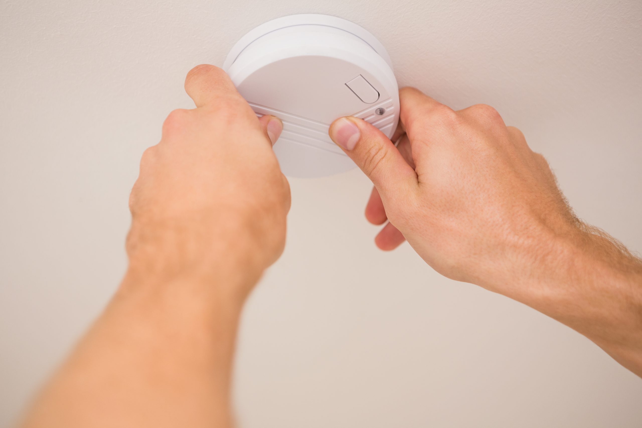handyman installing smoke detector 1 scaled